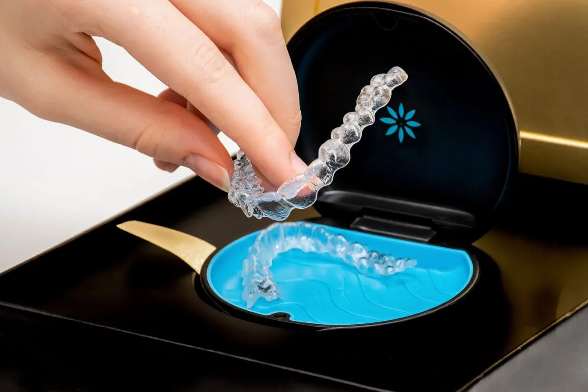 Patient placing Invisalign clear aligners into a case at Futch Dental in Reno, NV